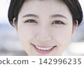 一張健康女性的肖像照，她面帶微笑，露出牙齒。 142996235