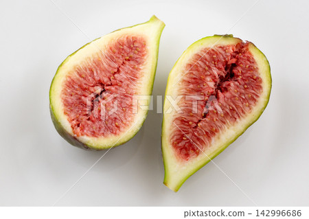 白色背景上,一顆完美成熟的無花果的漂亮橫截面。 白色背景上,一顆完美成熟的無花果的漂亮橫截面。 142996686