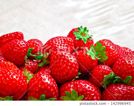 Strawberries in clear plastic box with water drops 142996945