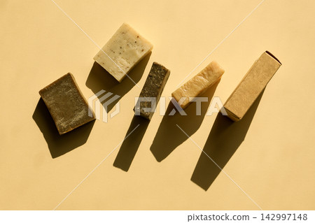 Five different soap bars are arranged in a line with shadows 142997148