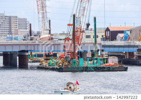 Crane barge, steel pipe piles, and patrol boat used to construct a temporary bridge during bridge replacement work. Crane barge, steel pipe piles, and patrol boat used to construct a temporary bridge during bridge replacement work. 142997222