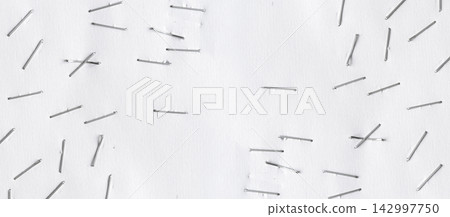Staples pushed into a paper, metal office staple needles Staples pushed into a paper, metal office staple needles 142997750