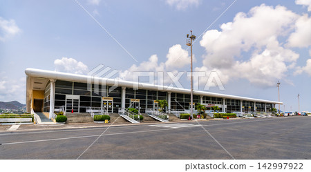 Exterior view of the main terminal building at Robert L Bradshaw International Airport under a blue sky in Basseterre, Saint Kitts. Exterior view of the main terminal building at Robert L Bradshaw International Airport under a blue sky in Basseterre, Saint Kitts. 142997922