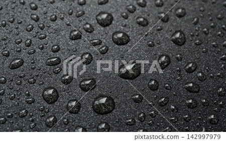 Oil drops on frying pan texture, water splash pattern on black non-stick coating Oil drops on frying pan texture, water splash pattern on black non-stick coating 142997979