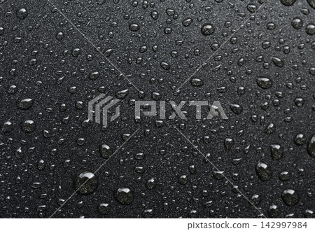 Oil drops on frying pan texture, water splash pattern on black non-stick coating 142997984