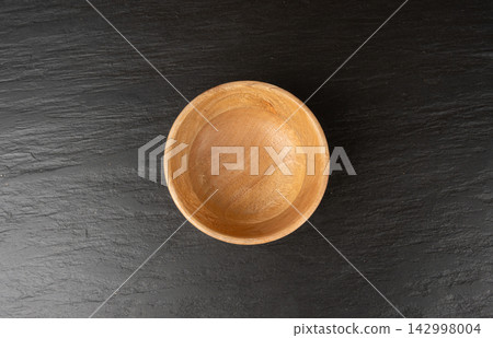 Empty wood bowl on black tabletop, light wooden plate, moody dish mockup, kitchen banner Empty wood bowl on black tabletop, light wooden plate, moody dish mockup, kitchen banner 142998004