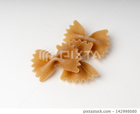 Raw Brown Farfalle Pasta Isolated Raw Brown Farfalle Pasta Isolated 142998080