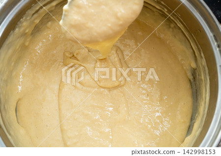 Making dough with spoon, kneading batter for pancakes Making dough with spoon, kneading batter for pancakes 142998153