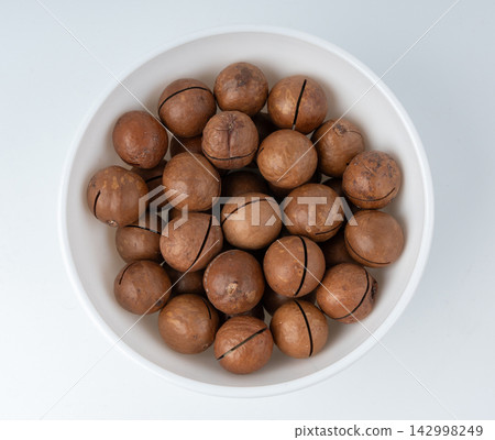 Macadamia nuts isolated. Natural raw peeled macadamia seeds and shells Macadamia nuts isolated. Natural raw peeled macadamia seeds and shells 142998249