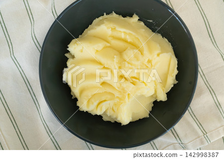Mash potato in black bowl closeup Mash potato in black bowl closeup 142998387