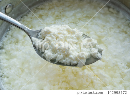 Cottage cheese making, curd in whey texture closeup Cottage cheese making, curd in whey texture closeup 142998572