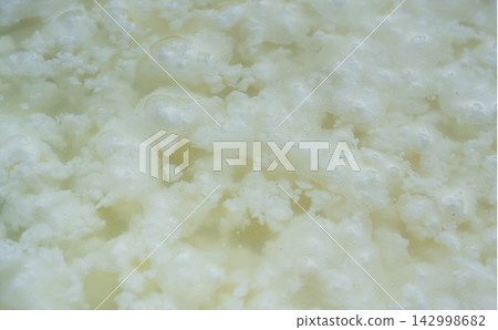 Cottage cheese making, curd in whey texture closeup Cottage cheese making, curd in whey texture closeup 142998682