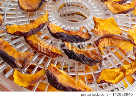 Dried nectarines and peaches in fruit dryer close up Dried nectarines and peaches in fruit dryer close up 142998940