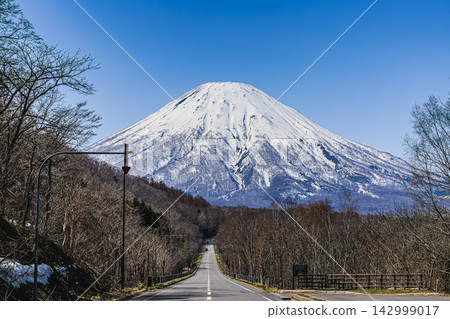 北海道，支笏洞爺國立公園：沿著筆直的公路行駛，背景是白雪皚皚的雄偉的羊蹄山，令人心曠神怡。 142999017