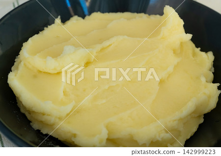 Mash potato in black bowl closeup 142999223