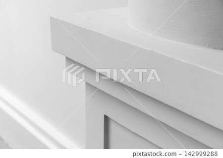 A close-up view of white interior architectural trim and a round column molding A close-up view of white interior architectural trim and a round column molding 142999288