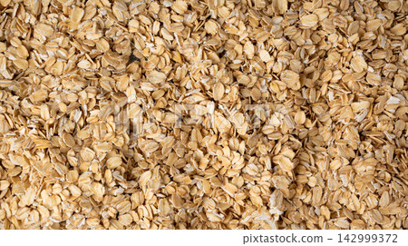 Oat flakes textured pattern, rolled oatmeal macro background Oat flakes textured pattern, rolled oatmeal macro background 142999372