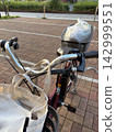 一輛裝滿購物袋的自行車，以及一幅日常景象。 142999551