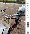 一輛裝滿購物袋的自行車，以及一幅日常景象。 142999552