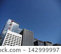 The urban landscape of Tokyo, depicted against the backdrop of its blue sky and skyscrapers. 142999997