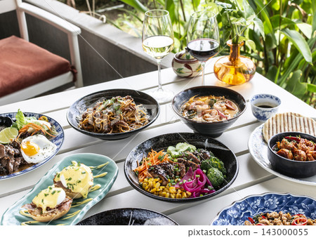 Mixed fusion western and asian lunch food spread on modern outdoor restaurant table Mixed fusion western and asian lunch food spread on modern outdoor restaurant table 143000055