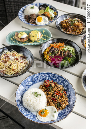 Mixed fusion western and asian lunch food spread on modern outdoor restaurant table Mixed fusion western and asian lunch food spread on modern outdoor restaurant table 143000057