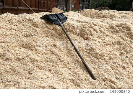 Sawdust pile with shovel for biomass industry waste Sawdust pile with shovel for biomass industry waste 143000840