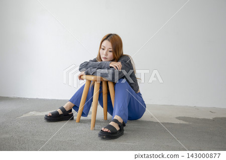 A beautiful Japanese woman leaning back in a chair, looking relaxed. A beautiful Japanese woman leaning back in a chair, looking relaxed. 143000877