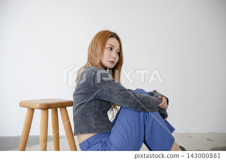 A beautiful Japanese woman leaning back in a chair, looking relaxed. A beautiful Japanese woman leaning back in a chair, looking relaxed. 143000881