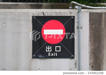 混凝土牆上安裝了「禁止入內」標誌和帶有日文和英文文字的出口標誌。 143002298