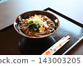Warm Japanese-style soba noodles with green onions and wakame seaweed. 143003205