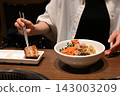 A scene of people enjoying meat and bibimbap at a yakiniku restaurant. 143003209