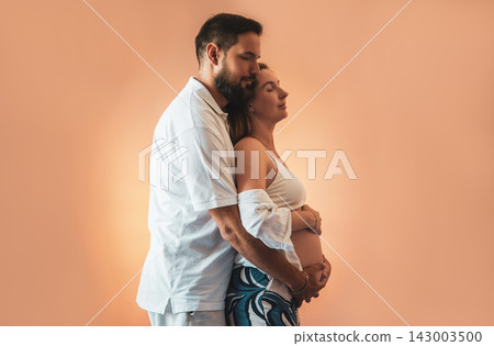 Expectant Couple Embracing During Pregnancy, Loving Future Parents Preparing for Baby Expectant Couple Embracing During Pregnancy, Loving Future Parents Preparing for Baby 143003500