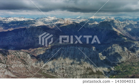 Aerial view of rocky mountain peak and green valley Aerial view of rocky mountain peak and green valley 143004031