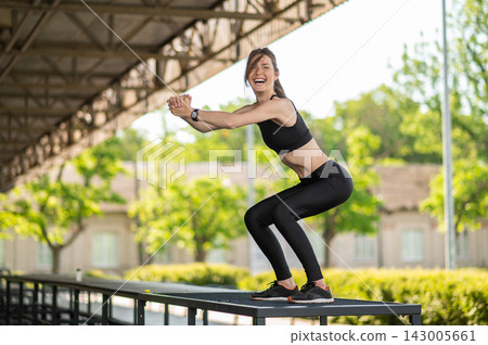 Slim young woman in black sportswear having a workout Slim young woman in black sportswear having a workout 143005661