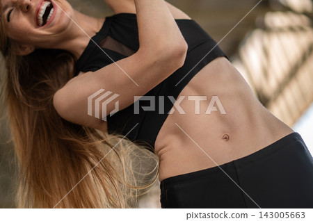 Slim young woman in black sportswear having a workout Slim young woman in black sportswear having a workout 143005663