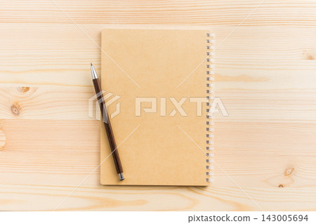 Top view of vertical kraft paper spiral notebook mockup on light wooden background Top view of vertical kraft paper spiral notebook mockup on light wooden background 143005694