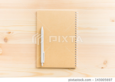 Top view of vertical kraft paper spiral notebook mockup on light wooden background Top view of vertical kraft paper spiral notebook mockup on light wooden background 143005697