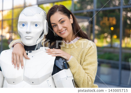 Cheerful woman embracing white cybernetic android Cheerful woman embracing white cybernetic android 143005715