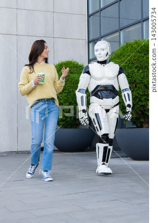 Smiling female holding coffee cup talking to humanoid robot Smiling female holding coffee cup talking to humanoid robot 143005734