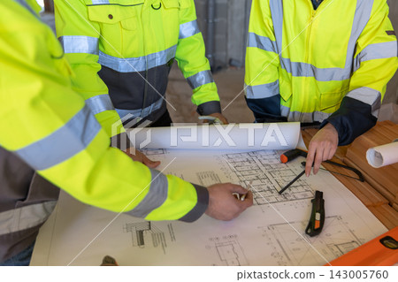 Close-up of architects discussing building blueprints Close-up of architects discussing building blueprints 143005760