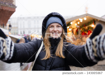 Happy young woman spinning around at Christmas market in Krakow Poland Happy young woman spinning around at Christmas market in Krakow Poland 143005867