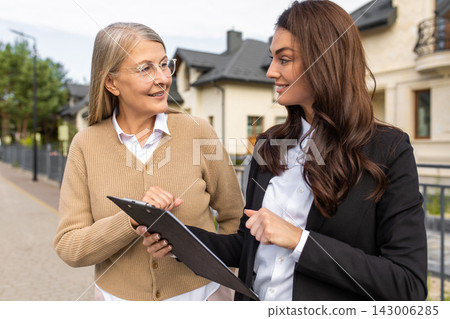 Real estate agent talking to the client and both looking involved Real estate agent talking to the client and both looking involved 143006285