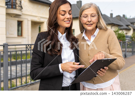 Real estate agent talking to the client and both looking involved Real estate agent talking to the client and both looking involved 143006287