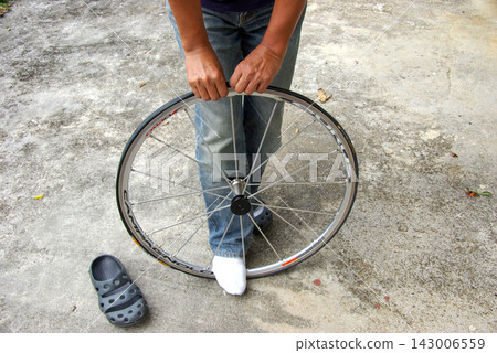 A cyclist with a removed wheel A cyclist with a removed wheel 143006559