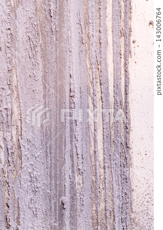 Rough textured wall surface displaying vertical streaks of light grey paint or concrete creating an abstract pattern and gritty background Rough textured wall surface displaying vertical streaks of light grey paint or concrete creating an abstract pattern and gritty background 143006764