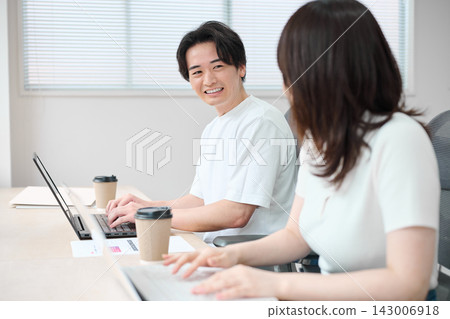 穿著商務休閒服的男男女女正在使用電腦。 143006918