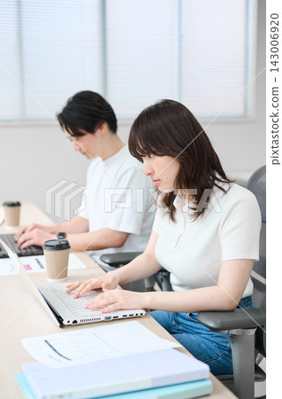 穿著商務休閒服的男男女女正在使用電腦。 穿著商務休閒服的男男女女正在使用電腦。 143006920