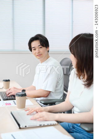 穿著商務休閒服的男男女女正在使用電腦。 穿著商務休閒服的男男女女正在使用電腦。 143006923