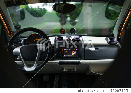 Interior view of a modern compact city car cabin with black seats Interior view of a modern compact city car cabin with black seats 143007105